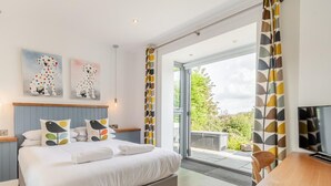 Een moderne slaapkamer met een bed, een bureau en een televisie.