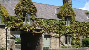 A stone building with ivy-covered walls and a green door. - 3 Bed in Backworth (oc-cn013) (Backworth)