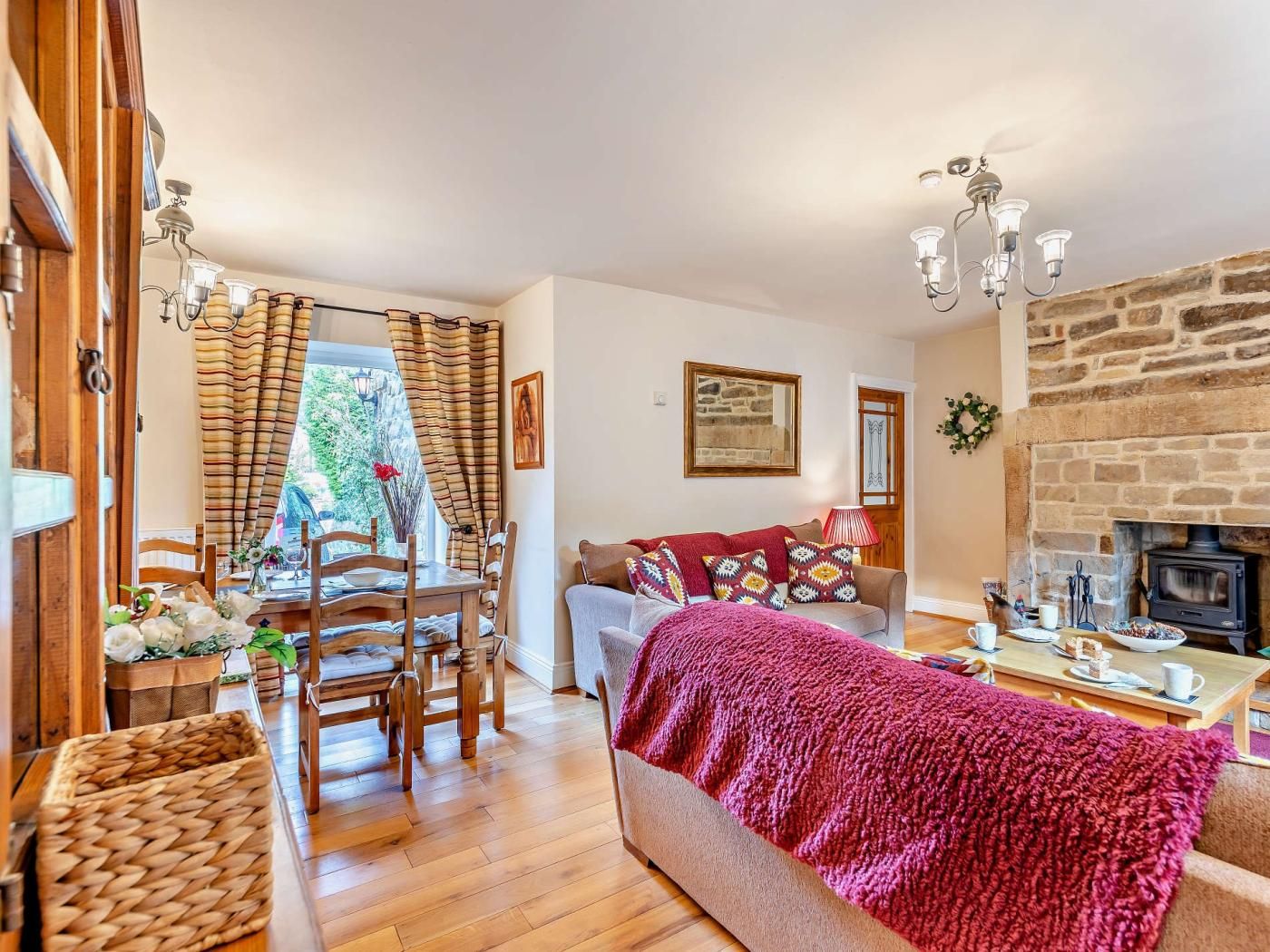 Un salón acogedor con chimenea, muebles de madera y un comedor con una mesa lista para dos.