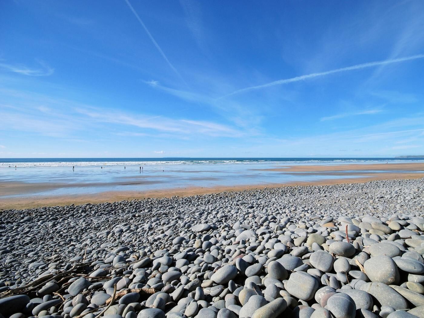 Une plage de galets sous un ciel dégagé.