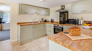 A modern kitchen with light-colored cabinets, a wooden countertop, a built-in oven, and a toaster. - 3 Bed in Torrington (oc-58822) (Langtree)