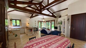 A spacious room with a large bed, a dining table, and a kitchen area. - Holiday Home 'Villa Moutiques' with Private Terrace, Private Garden and Wi-Fi (Cazaubon)