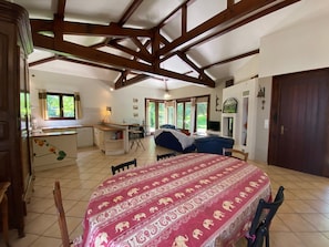 A spacious room with a large bed, a dining table, and a kitchen area. - Holiday Home 'Villa Moutiques' with Private Terrace, Private Garden and Wi-Fi (Cazaubon)