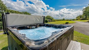 A hot tub with a wooden deck and a clear view of the surrounding landscape. - 5 Bed in Aberystwyth (oc-58889) (Llanrhystyd)