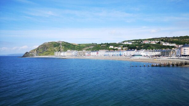 A coastal town with a beach, buildings, and a hill. - 5 Bed in Aberystwyth (oc-58889) (Llanrhystyd)