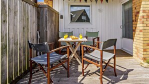A patio with a table and chairs, a wooden fence, and a brick wall. - 2 Bed in Chathill (oc-cn028) (Beadnell)