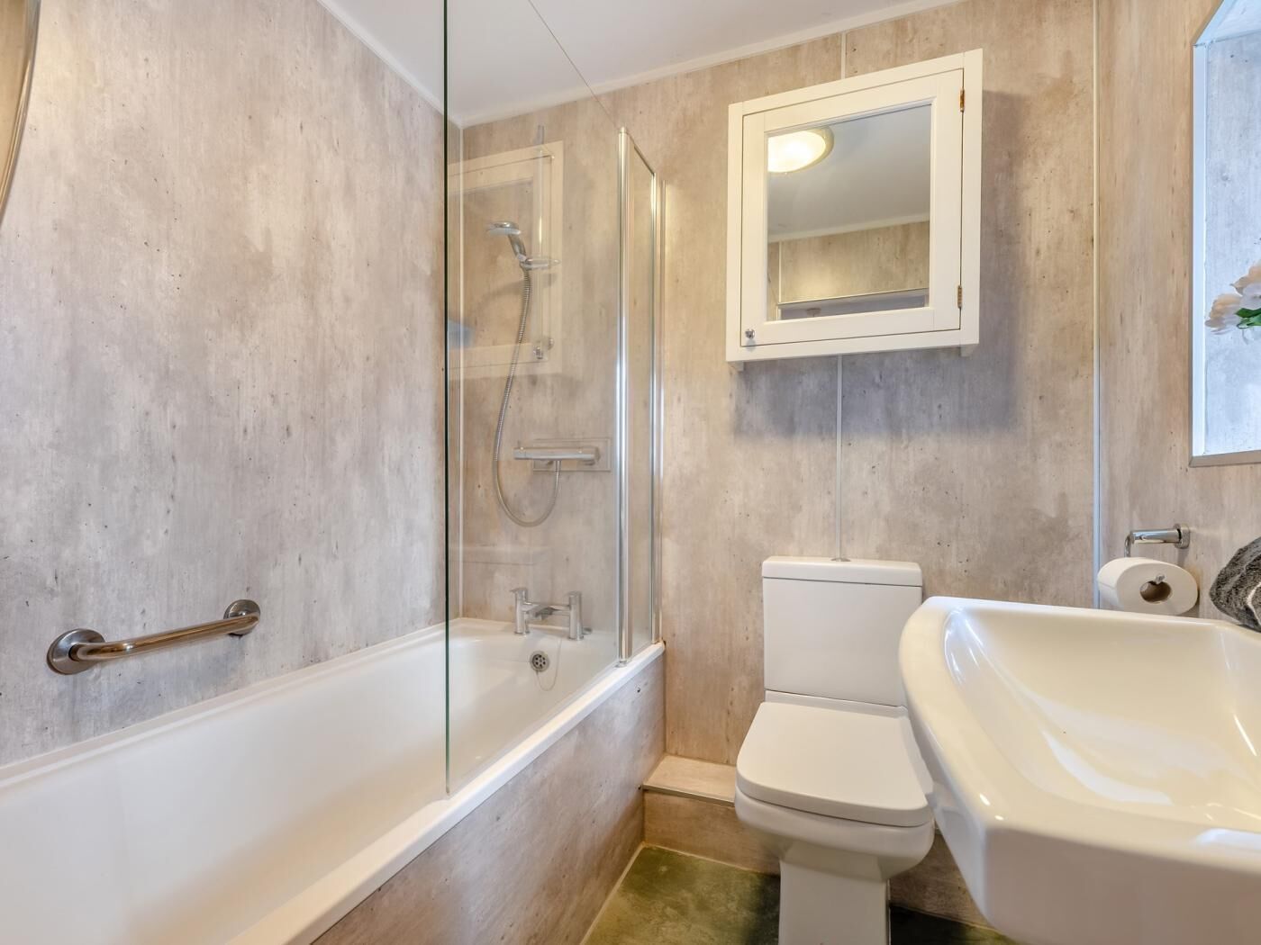 A bathroom with a bathtub, a glass-enclosed shower, a toilet, and a sink.