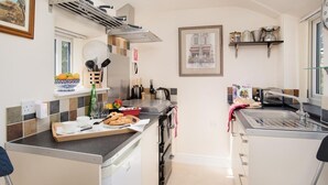 A compact kitchen with a built-in oven, a sink, and a window. - 1 Bed in Riding Mill (oc-cn063) (Corbridge)