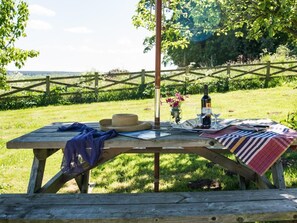 A wooden picnic table set outdoors with a bottle, glasses, and a basket. - 1 Bed in Riding Mill (oc-cn063) (Corbridge)