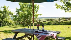 An outdoor picnic table with a bottle, glasses, and a hat. - 1 Bed in Riding Mill (oc-cn063) (Corbridge)