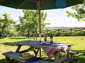 An outdoor picnic table with a bottle, glasses, and a hat. - 1 Bed in Riding Mill (oc-cn063) (Corbridge)