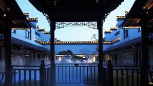 Ein traditionelles Gebäude mit einem zentralen Innenhof, Holzgeländern und einem verzierten Tor.