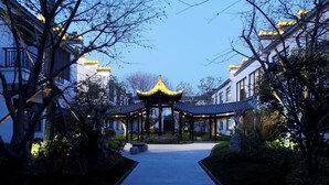 Ein Gebäude im traditionellen Stil mit einem zentralen Pavillon, umgeben von gepflegten Gärten und Wegen.