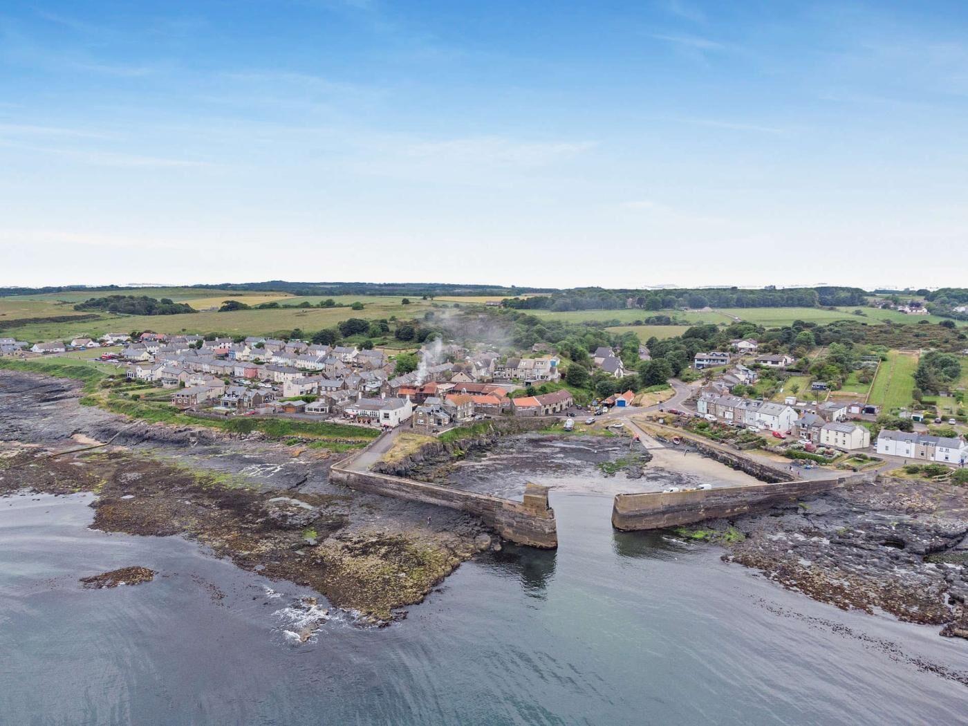 Une ville côtière dotée d’un port, de bâtiments et d’un ciel dégagé.