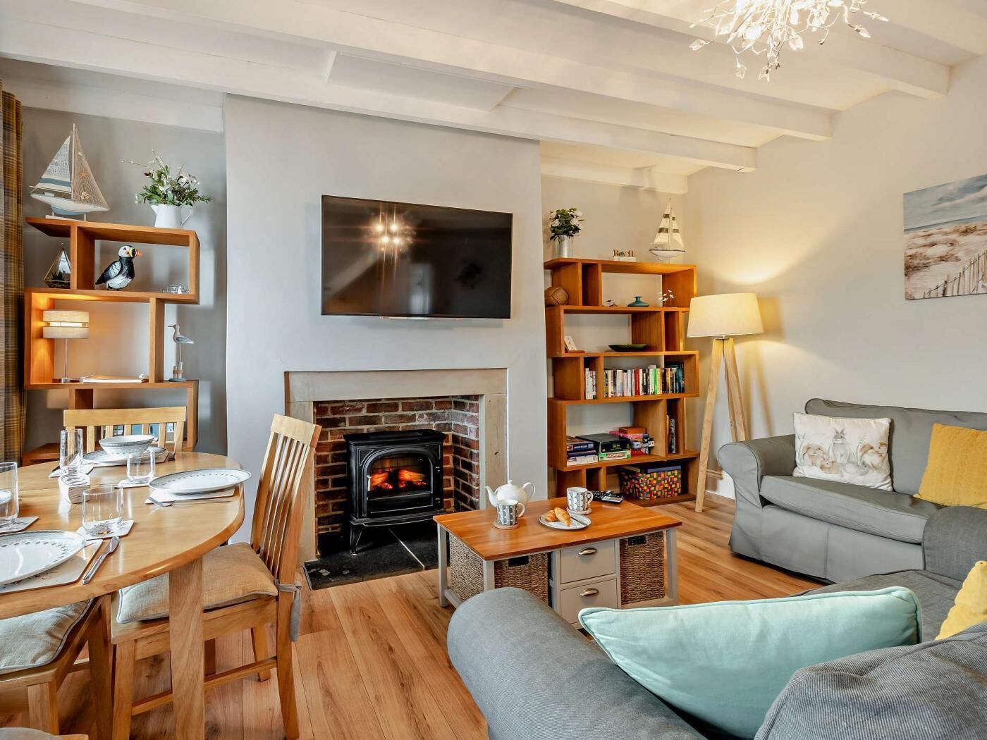 A cozy living room with a fireplace, a television, a bookshelf, and a sofa.