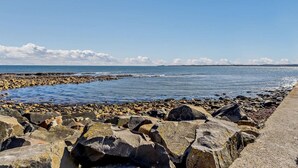 A rocky shoreline with a clear sky and calm sea. - 3 Bed in Beadnell (oc-cn119) (Beadnell)