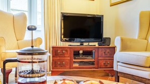 A living room with a television, a coffee maker, and a table with muffins. - 4 Bed in Consett (oc-cn108) (Hunstanworth)