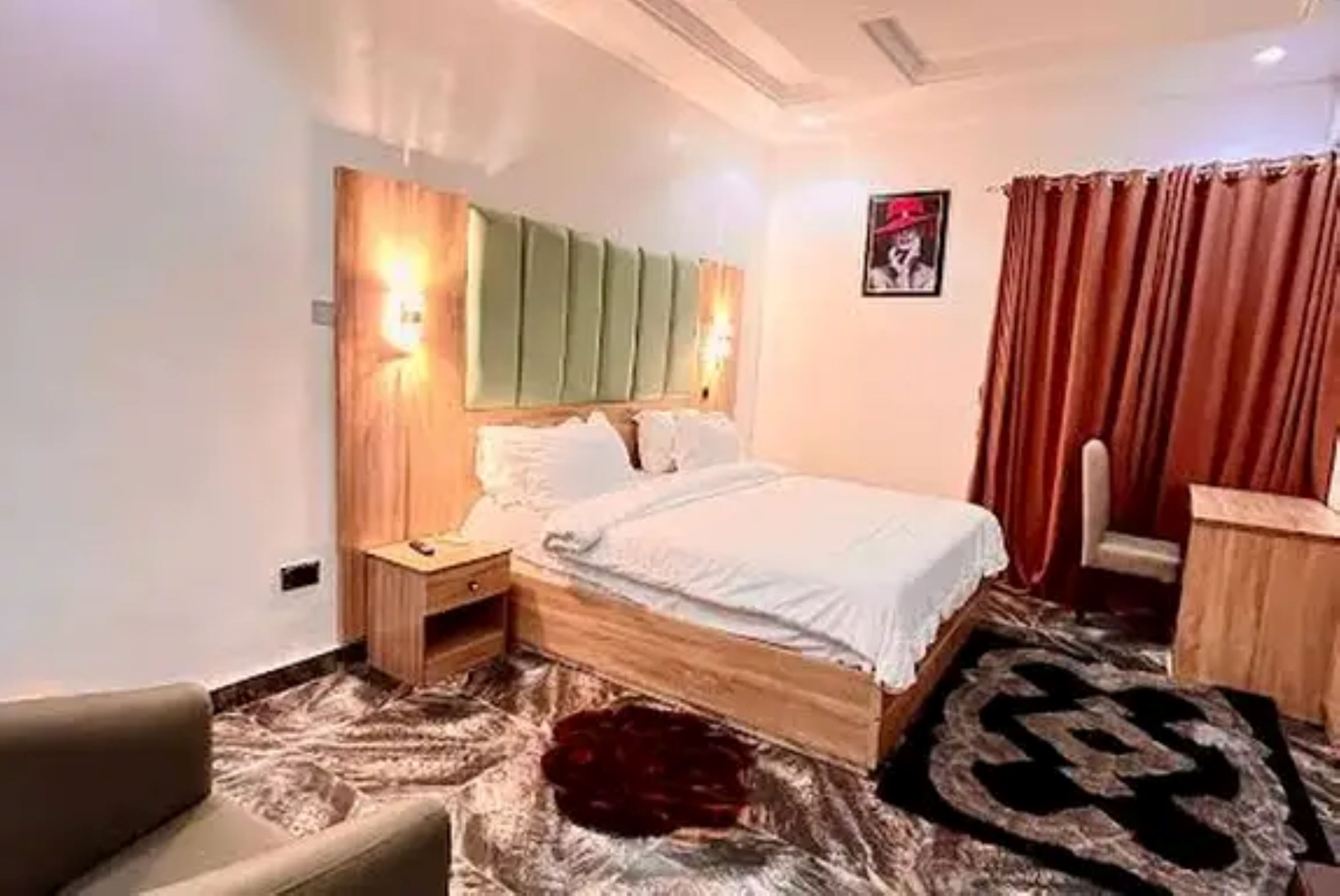 A bedroom with a bed, nightstands, a chair, and a rug.