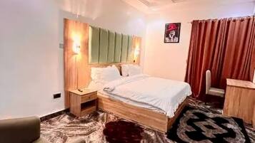 A bedroom with a bed, nightstands, a chair, and a rug.