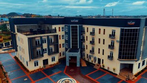 A multi-story building with balconies, a central courtyard, and a sign indicating 'DE NEW DAWN.'