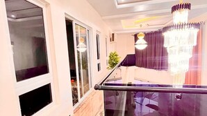 A modern interior with a glass balustrade, a chandelier, and a marble floor.
