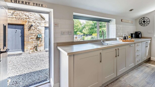 Una cocina moderna con pared de piedra, una ventana con vistas y un reloj en la pared.