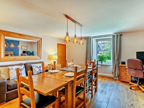 A dining area with a wooden table, chairs, and hanging pendant lights. - 2 Bed in Morpeth (oc-cn049) (Acklington)