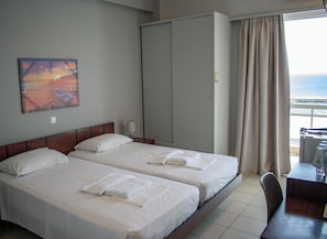 A hotel room with two beds, a large wardrobe, a desk, and a view of the sea. - Hotel ALS Karystos (Karystos)
