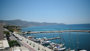 A marina with boats docked, a clear sky, and a mountainous backdrop. - Hotel ALS Karystos (Karystos)
