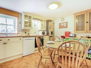 A kitchen with a dishwasher, microwave, and a dining table set for four. - 3 Bed in Consett (oc-cn110) (Hunstanworth)