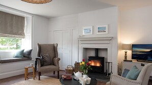 Una sala de estar acogedora con chimenea, asientos cómodos, una mesa de centro y una televisión.