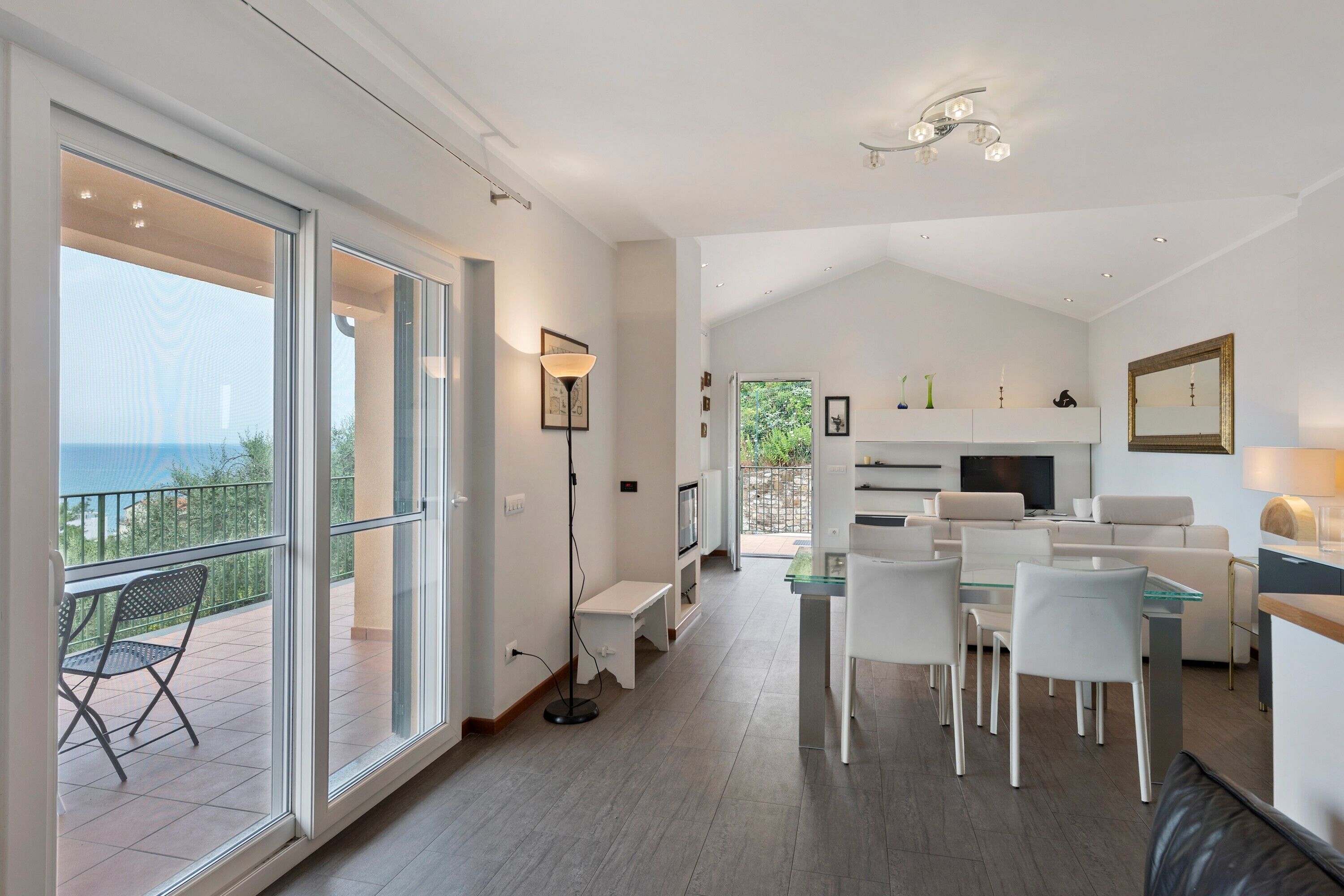 Un interior moderno con comedor, cocina y balcón con vistas.
