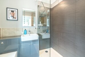 Un bagno moderno con cabina doccia in vetro, lavabo e specchio.