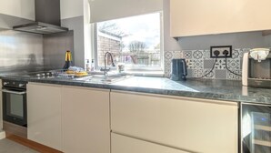 Una cocina moderna con un ventanal grande, electrodomésticos de acero inoxidable y un salpicadero decorativo.