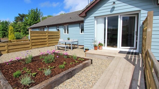 A house with a patio, a wooden fence, and a garden with flowers. - 3 Bed in Alnwick (oc-cn132) (Christon Bank)