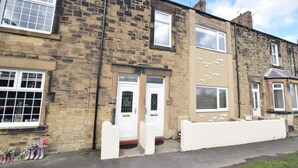 A two-story stone building with a white front door labeled 'PANHAVEN,' a small shop sign, and a white fence. - 3 Bed in Morpeth (oc-cn137) (Amble)