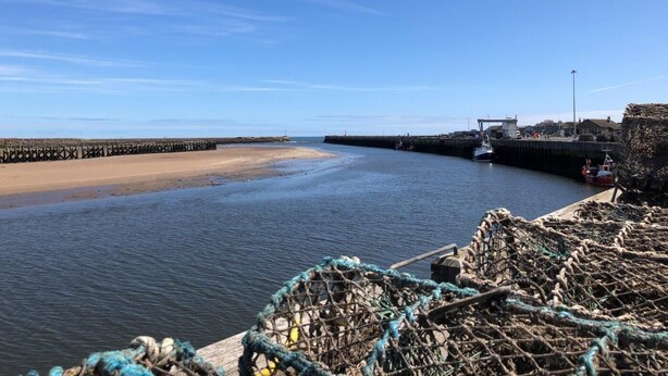 A coastal scene with a sandy beach, a calm sea, and a pier extending into the water. - 3 Bed in Morpeth (oc-cn137) (Amble)