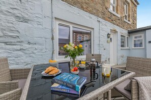 A table with books, breakfast items, and a coffee maker.