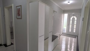 A hallway with white walls, a framed picture, and a white wardrobe. - Vacation rental, comfortable and modern, designed for discerning guests, near the main train station (Freudenstadt)