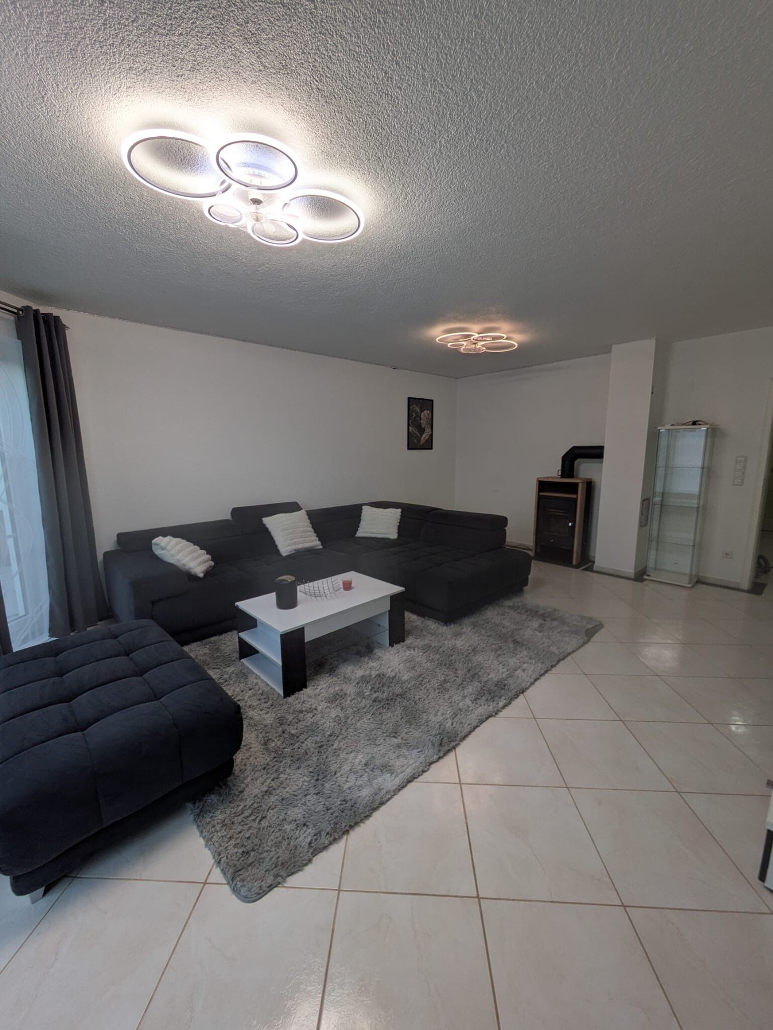 Una sala moderna con un sofá modular, una mesita de centro y una alfombra mullida.