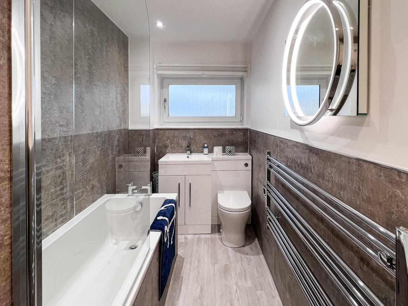 Une salle de bain moderne équipée d’une baignoire, de toilettes et d’un lavabo.