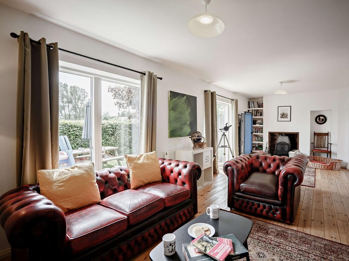 A living room with a leather sofa, a coffee table, and a fireplace.