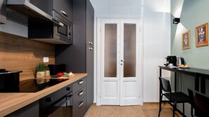 Eine moderne Küche mit Holzarbeitsplatte, eingebautem Backofen und einer Doppeltür mit gefrosteten Glasscheiben.