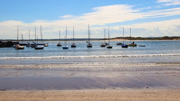 A beach with boats moored in the water. - 4 Bed in Beadnell (oc-cn167) (Beadnell)