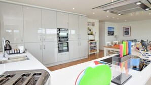 Eine moderne Küche mit weißen Schränken, einem Backofen, einer Spüle und einem Toaster.