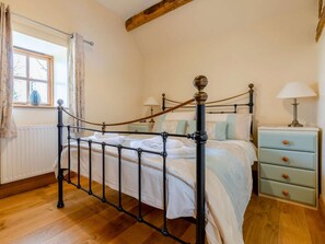 A bedroom with a four-poster bed, a nightstand with a lamp, and a window with curtains. - 2 Bed in Ludlow (oc-59293) (Richards Castle)