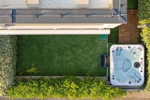A rooftop patio with a hot tub, a green lawn, and a wooden deck. - Pure Bliss Villa With Jacuzzi (Tisno)
