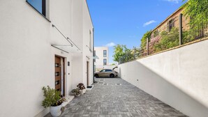 A narrow alleyway with a paved walkway, potted plants, and a parked car. - Pure Bliss Villa With Jacuzzi (Tisno)
