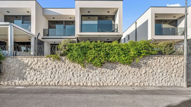 A modern building with a stone wall and greenery. - Pure Bliss Villa With Jacuzzi (Tisno)