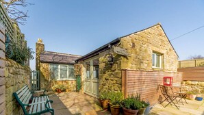 A stone house with a patio, a bench, and potted plants. - 1 Bed in Alnwick (oc-cn212) (Bilton)